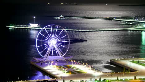 ferris wheel on the background of the sea and the lunar path. time lapse