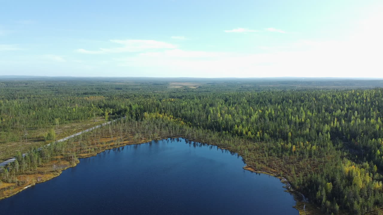 평평한 스칸디나비아 북부 숲의 가을 습지 연못의 플라이오버