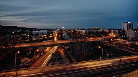 Zeitraffer-Des-Sonnenuntergangs,-Der-Lichter-Der-Stadt-Und-Der-Lichtspuren-Der-Autos-An-Einer-Kreuzung-In-Wien