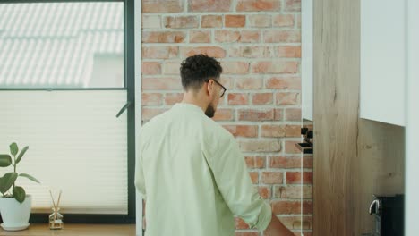 hombre abriendo el horno en la cocina moderna
