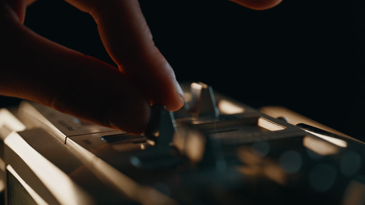 Music listener turning player touching switches at vintage panel in room closeup