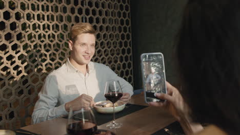 couple enjoying a meal at a restaurant and taking a picture