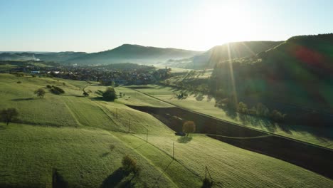 Vista-Aérea-De-Los-Campos-Agrícolas-Durante-El-Sol-De-La-Mañana-En-El-Campo-De-Suiza,-Tiro-De-Drones-Tranquilo-Y-Relajante