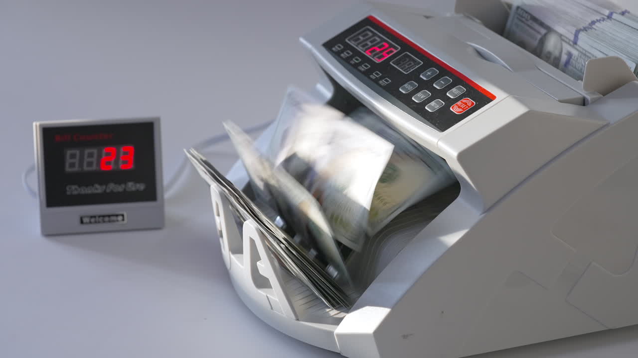 Compact electronic money counting equipment. A pack of hundred dollars counted quickly in the cash machine. Close up.