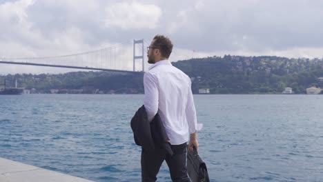 Businessman-walking-by-the-sea.