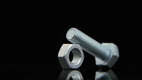 metal bolt and nut on a reflective black background