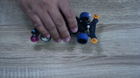 probando un automóvil deportivo tamiya mini 4x4 para su alineación y equilibrio dejándolo caer muchas veces sobre la mesa en una tienda de automóviles controlados a distancia en bangkok, tailandia