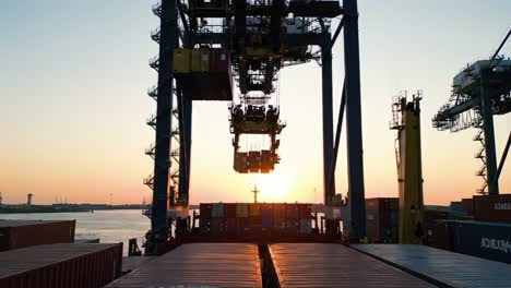 a stunning sunset over a busy cargo port - cranes hauling containers in twilight, showcasing the vibrant colors and industrial operations at dusk