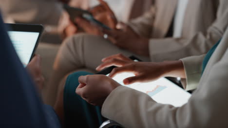 diverse business people using digital tablet computers browsing financial graph information on screen colleagues brainstorming ideas in office meeting