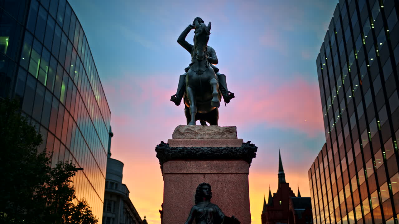 Prince Albert Equestrian Statue at sunset in London, United Kingdom. Modern buildings around, the sunset sky on the background