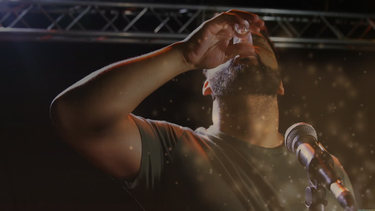 man sprinkling golden particles into mic on music stage, blending live action with animated data