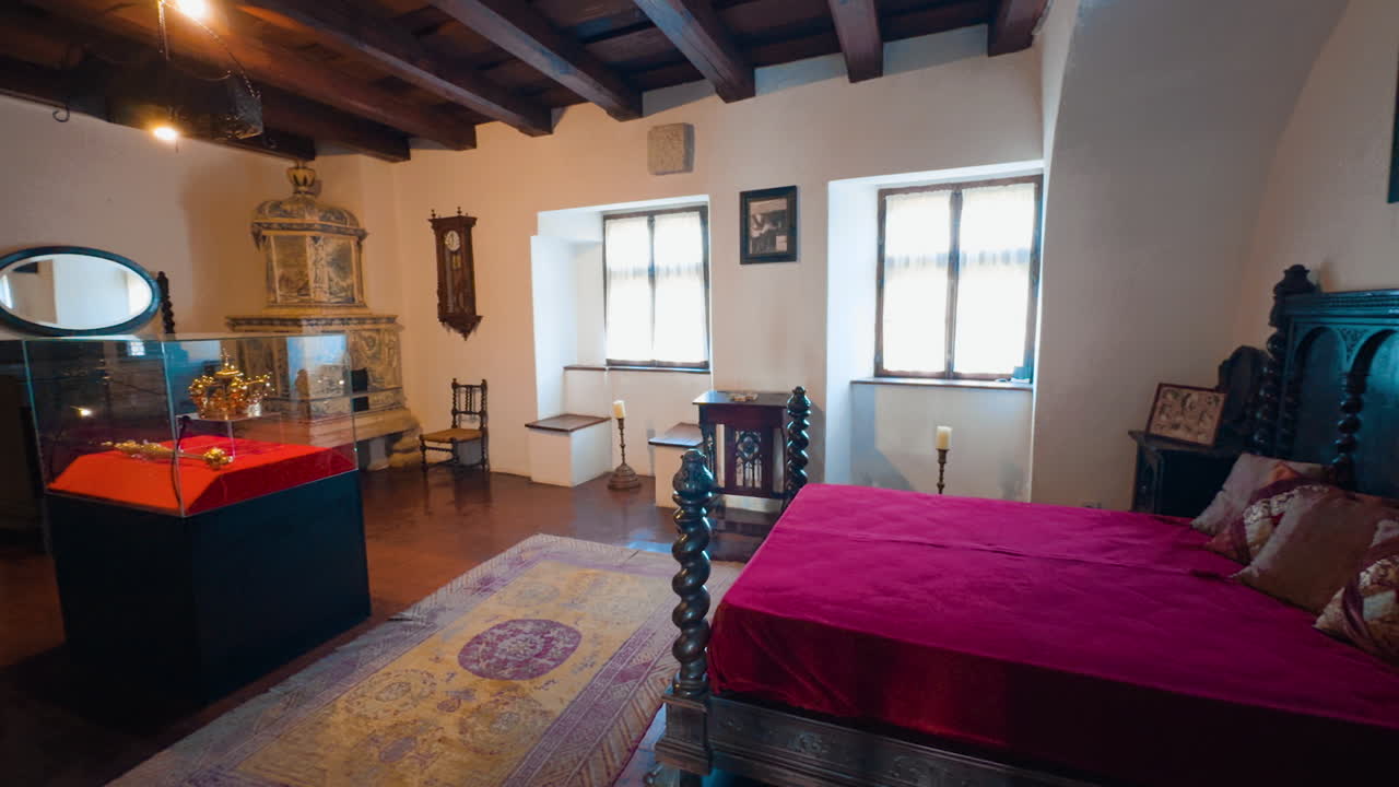 Spacious bedroom in the old medieval castle of Bran, Brasov, Transylvania, Romania. Antique furniture and wooden ceiling in the interior.