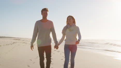 loving couple walking along winter beach together