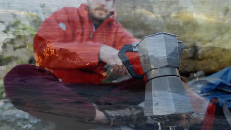 animation of landscape over caucasian male hiker preparing coffee