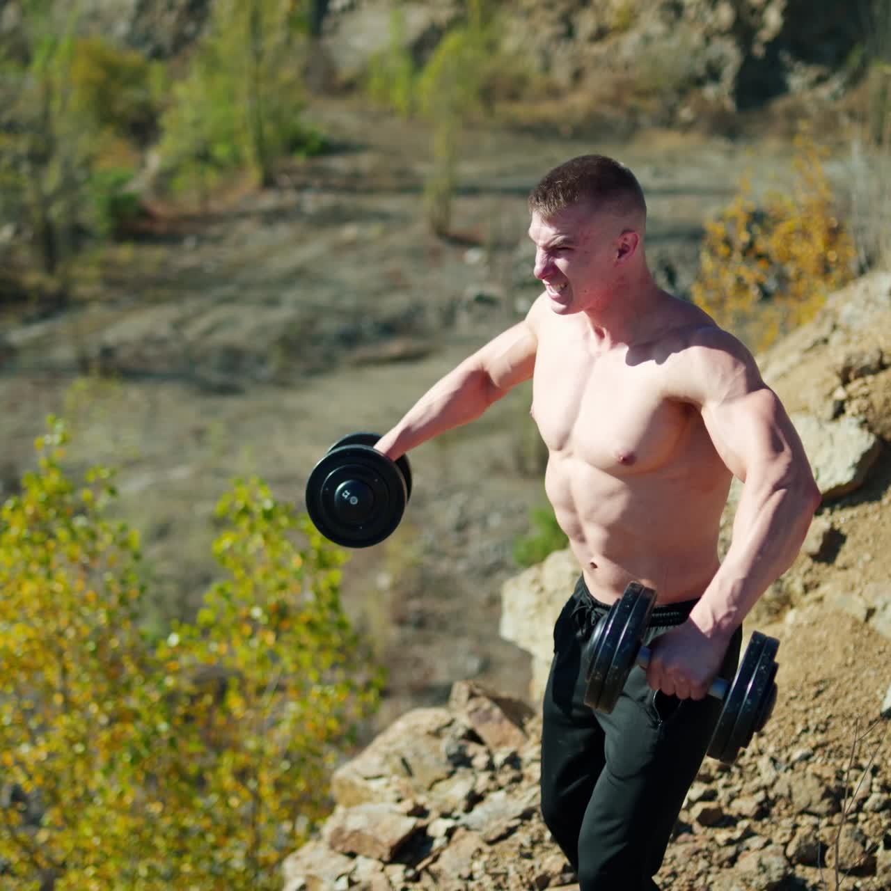 . Sporty man with dumbbells. Muscular man exercising with dumbbells