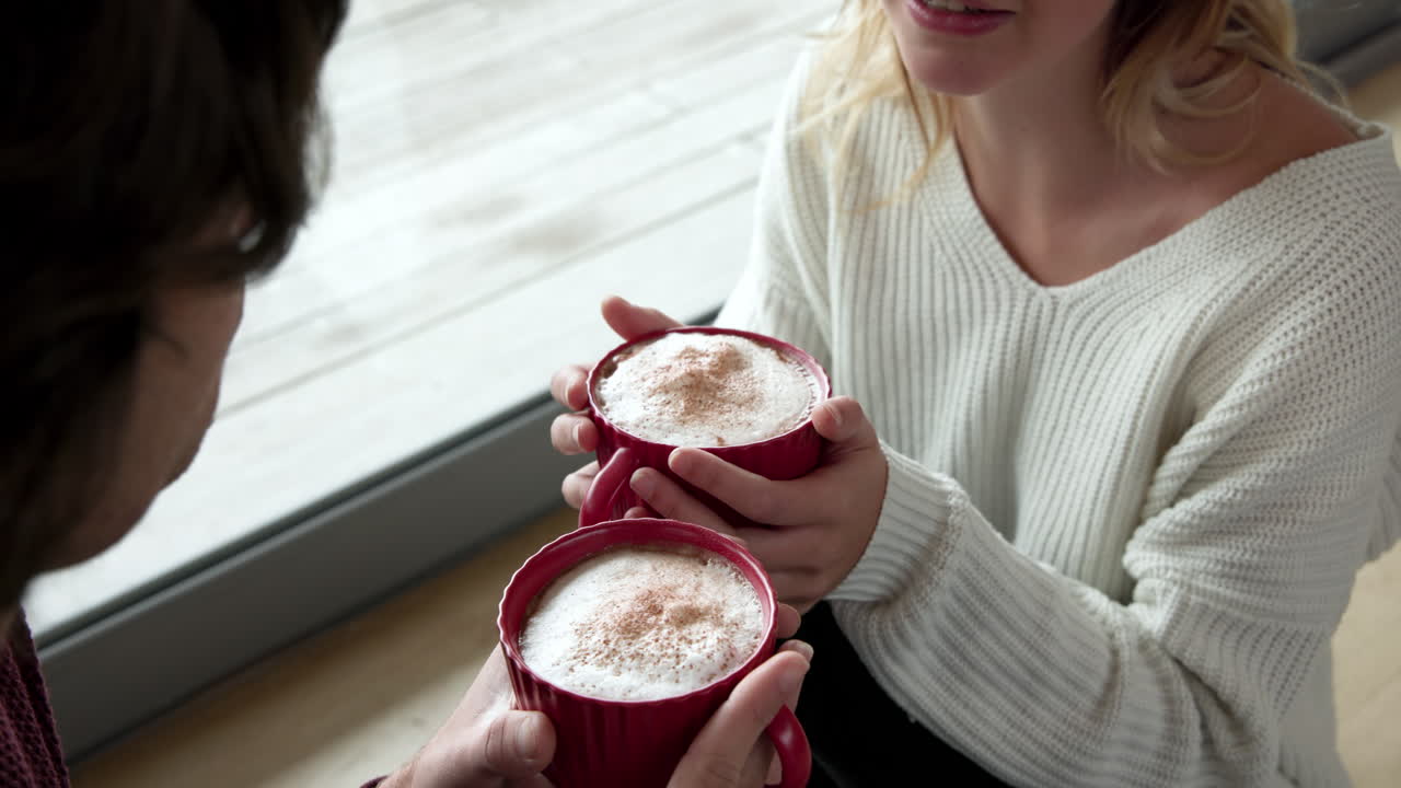 Cozy couple enjoying hot cocoa together at home during Christmas season