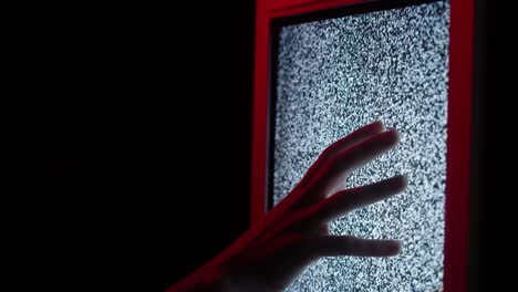 human hand touching old retro television screen with ripples, wavy flowing damaged signal. close-up of broken old-fashioned tv with noise, bad signal reception, cinematography concept