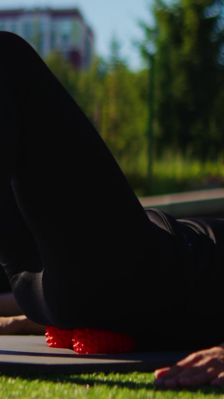 Persona che Usa il Foam Roller per Massaggio ai Glutei all'Aperto