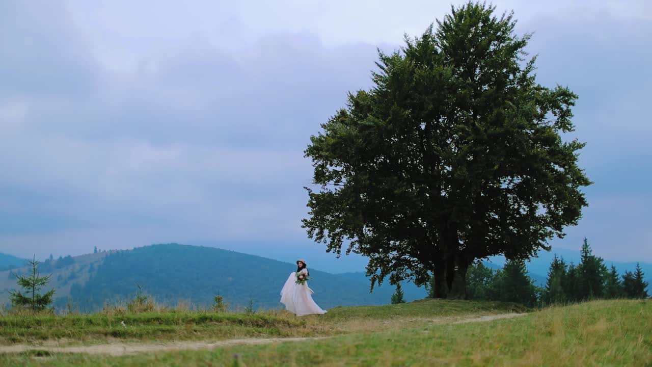 Woman posing over landscape of mountains. Stylish bride posing on the background of the mountain