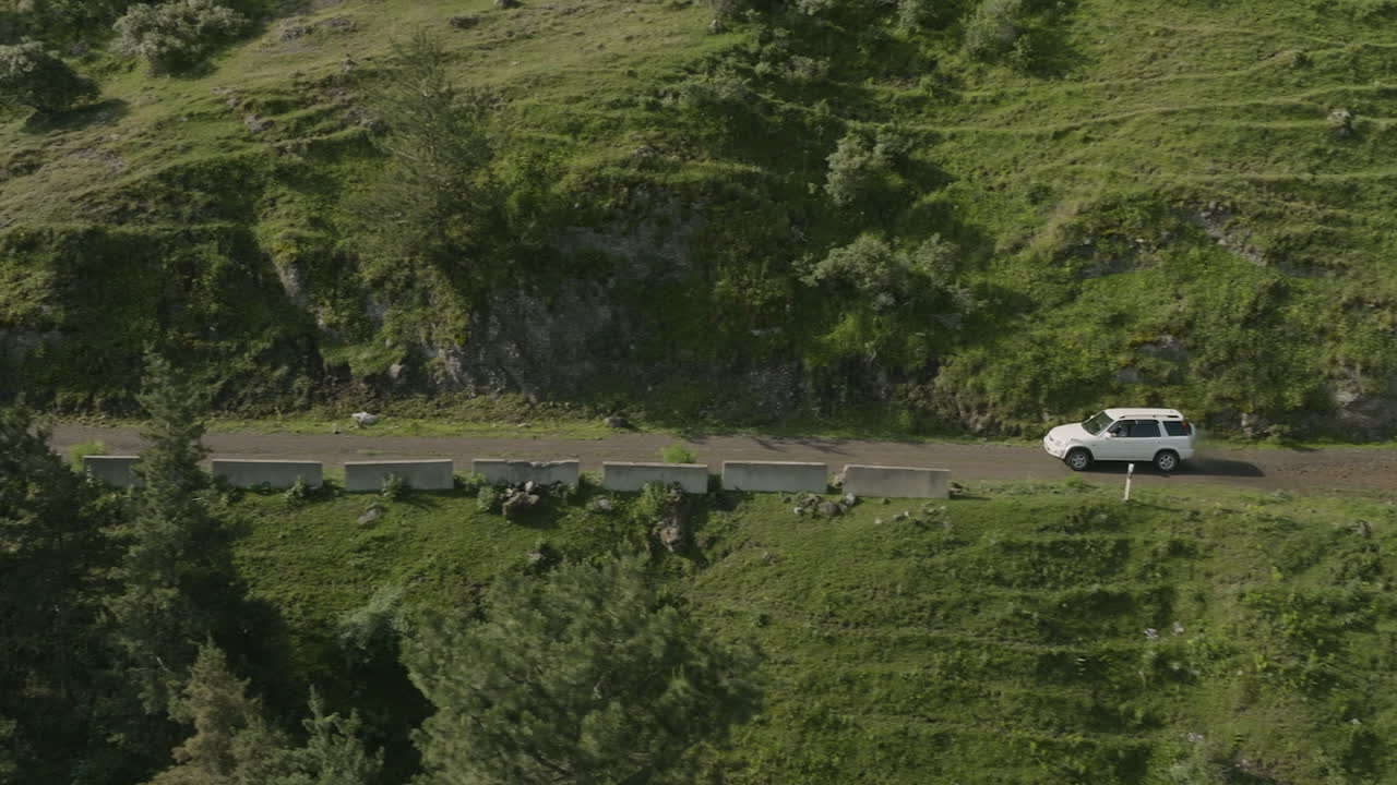 조지아 남부 코카서스 산맥의 구불구불한 도로에서 자동차가 운전하고 있습니다.