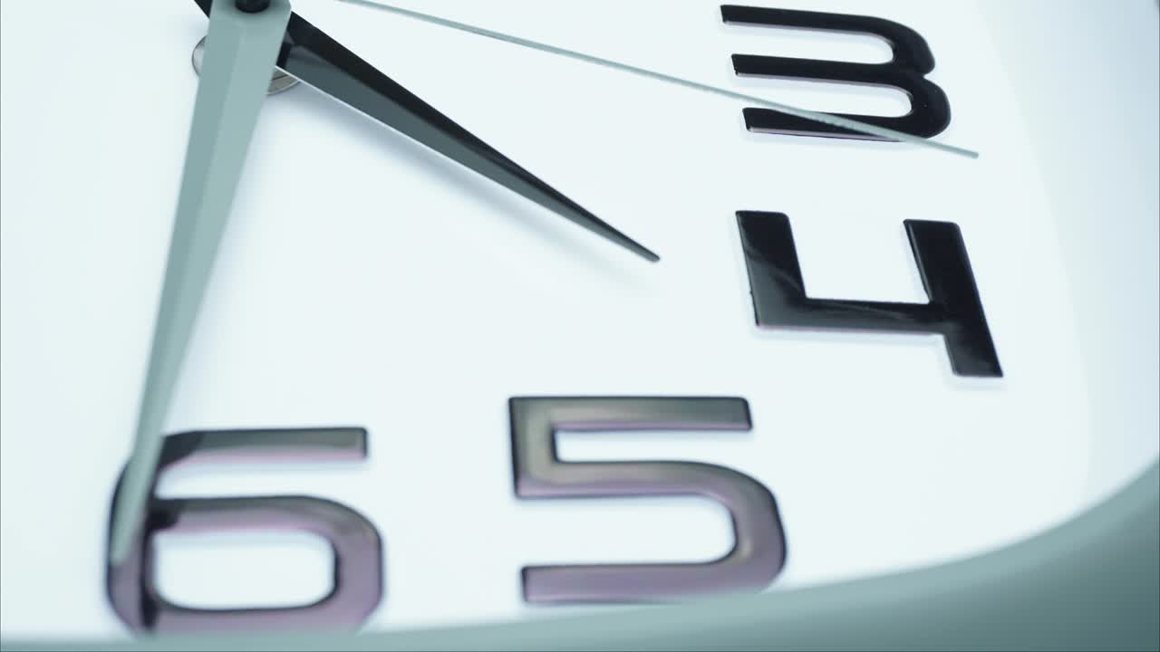 Close-up white wall clock tell the time 4:35 p.m.