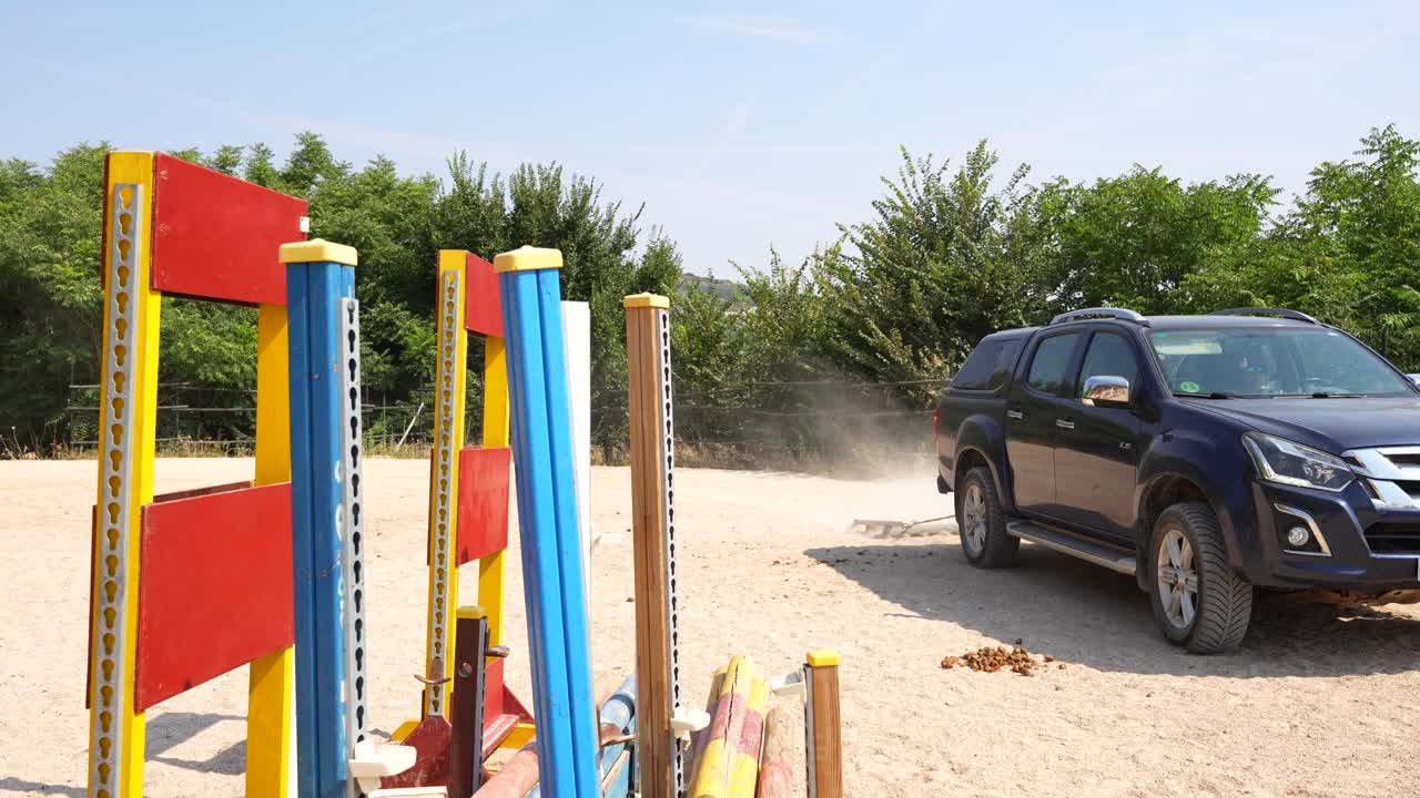 Horse riding arena repaired by a drag after training with ground obstacles