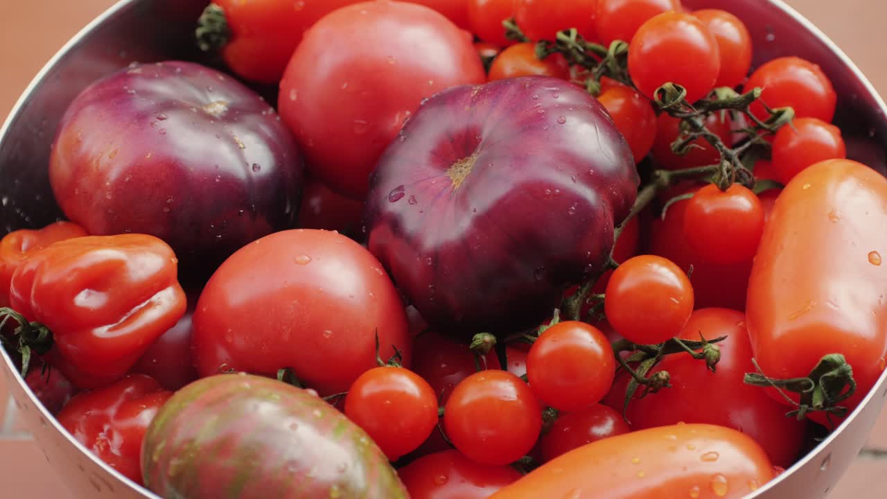 Colorful organic tomatoes. Mix tomatoes background, Several varieties of sliced tomatoes top view. Different assorted colorful tomatoes, heirloom, cherry, rose, beefsteak, cocktail, grape, purple.