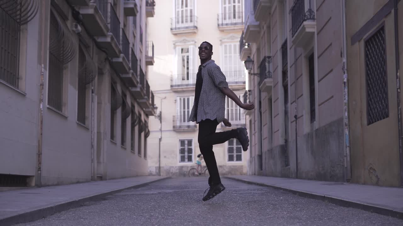 Man Jumping and Walking in a City Street