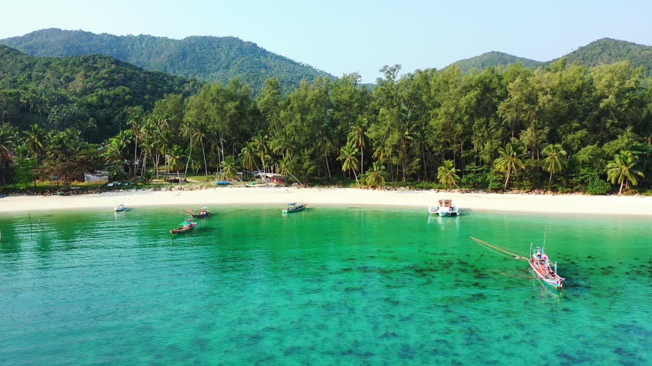 Malasia, barcos flotando en el agua cristalina de la isla tropical con playas de arena y bosque de palmeras