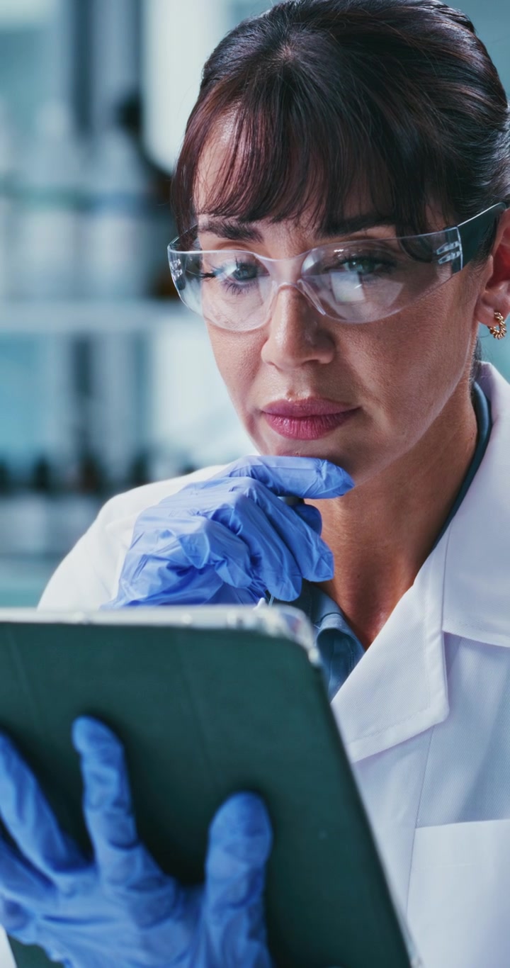 Scienziata che analizza dati su tablet in laboratorio