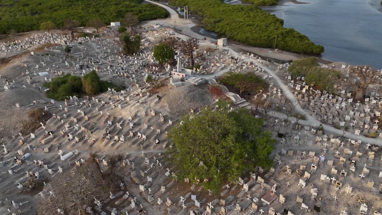 Aerial drone of Joal Fadiouth shell cemetery in Senegal, sacred interfaith burial ground built on seashells, surrounded by lagoon and mangroves