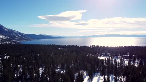 Aerial-drone-shot,-a-panorama-shot-of-the-crystal-clear-water-with-the-sun-reflecting-from-it-in-Lake-Tahoe,-Nevada-California