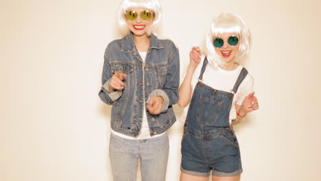 two women dancing in trendy outfits