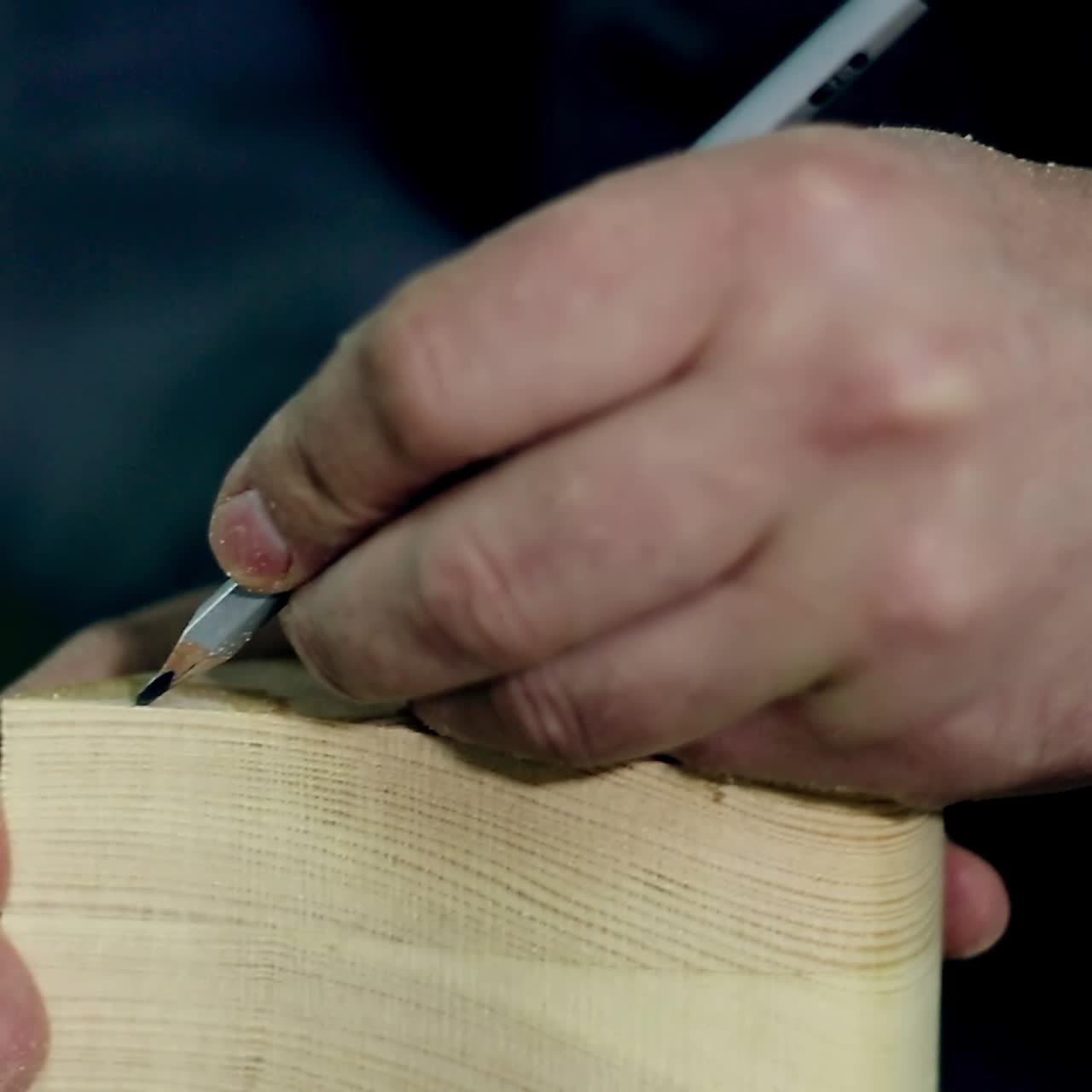 hombre usa una sierra eléctrica para cortar tablas de madera