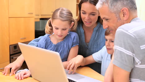 familia de pie mientras mira una computadora portátil