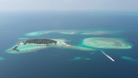 amazing aerial view of maldives islands with a boat, turquoise water, palms and white sandy beaches