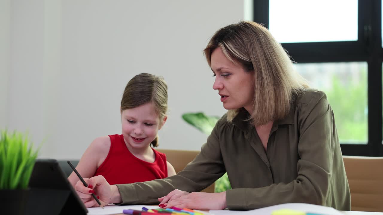 A woman and a girl drawing together