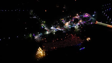 aerial drone flight over night market in thailand with floating lanterns