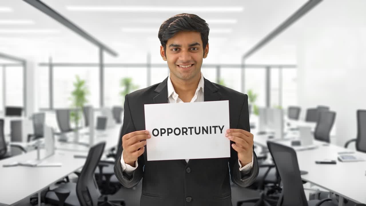 Happy Indian manager holding OPPORTUNITY banner