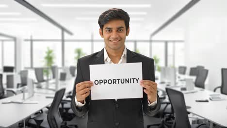 happy indian manager holding opportunity banner