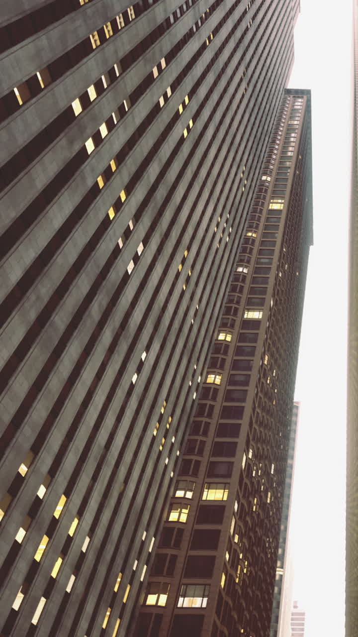 Skyscrapers reaching up into the cloudy sky of a bustling cityscape at twilight