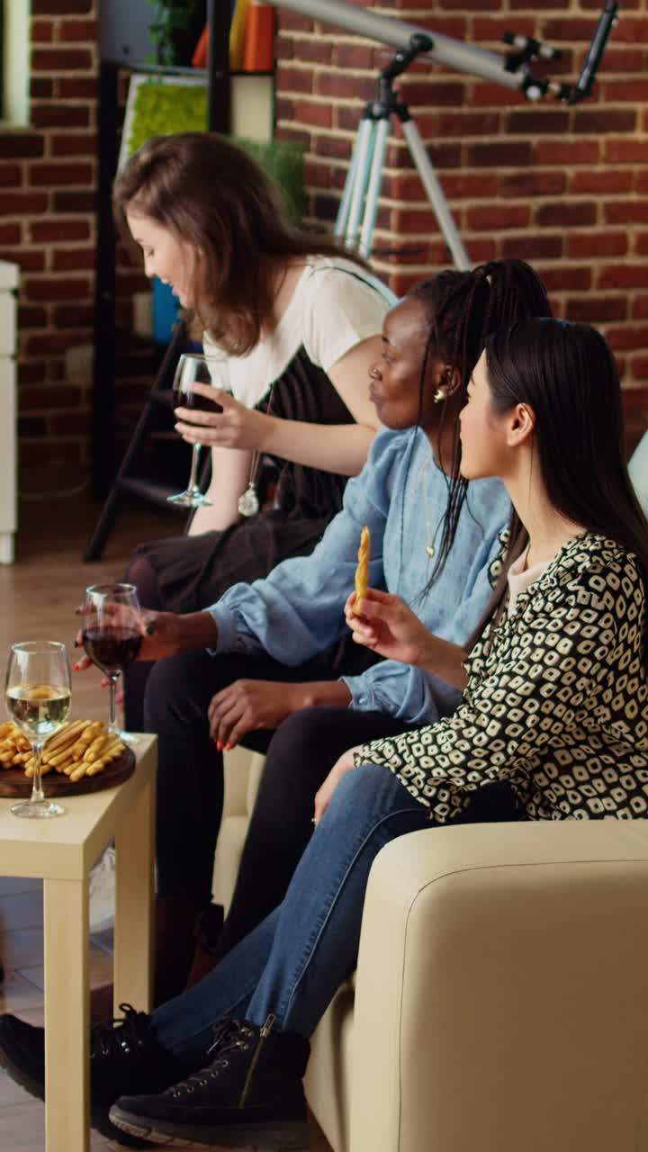 Vertical video Multicultural colleagues doing social gathering in cozy apartment