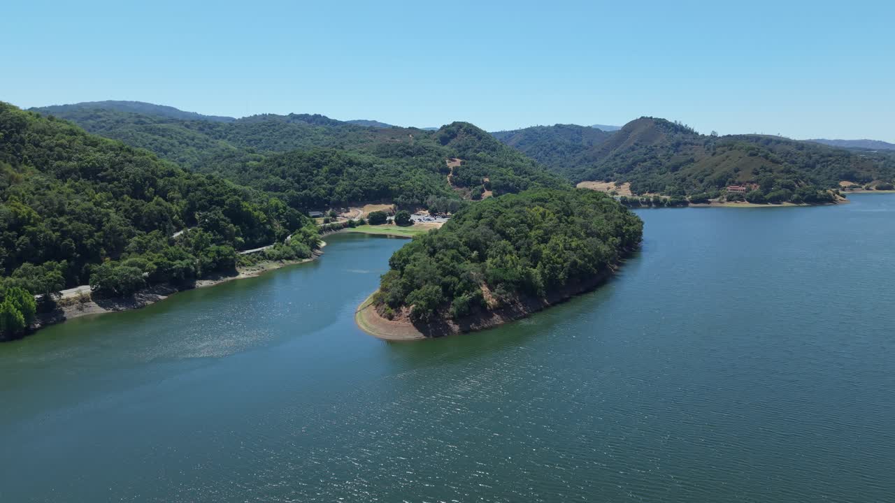 A tranquil view of Uvas Reservoir reveals its reflective waters surrounded by the golden hills of Morgan Hill