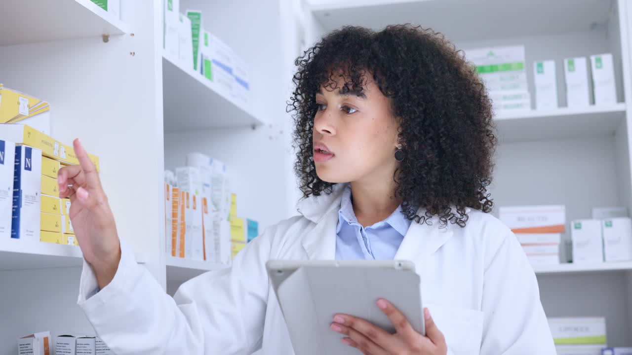 Black pharmacist doing inventory on a digital