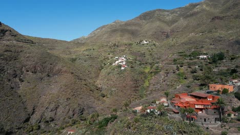 Circling-Drone-Shot-of-Man-Standing-on-Edge-of-Large-Mountain,-Tenerife-Spain