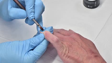 closeup shot of a woman in a nail salon receiving a manicure by a beautician with a nail file