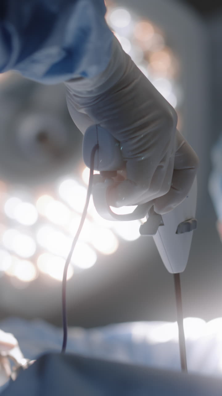 Adult male surgeon looks at monitor and operates p 4k 2025 08 05 02 28 54 utc.mov | adult, anesthesia, assist, assistance