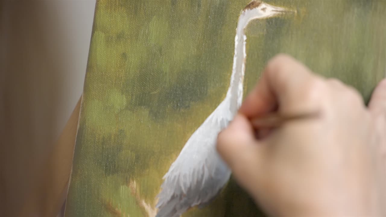 pan hacia abajo a través de la hermosa pintura al óleo de pájaro cisne en el caballete de los artistas, el pintor agrega plumas detalladas