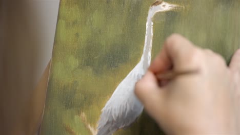 pan down across beautiful swan bird oil painting on artists easel, painter adds detailed feathers