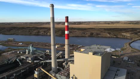 aerial 4k circle around coal and gas powered generating station in rural usa countryside next to river